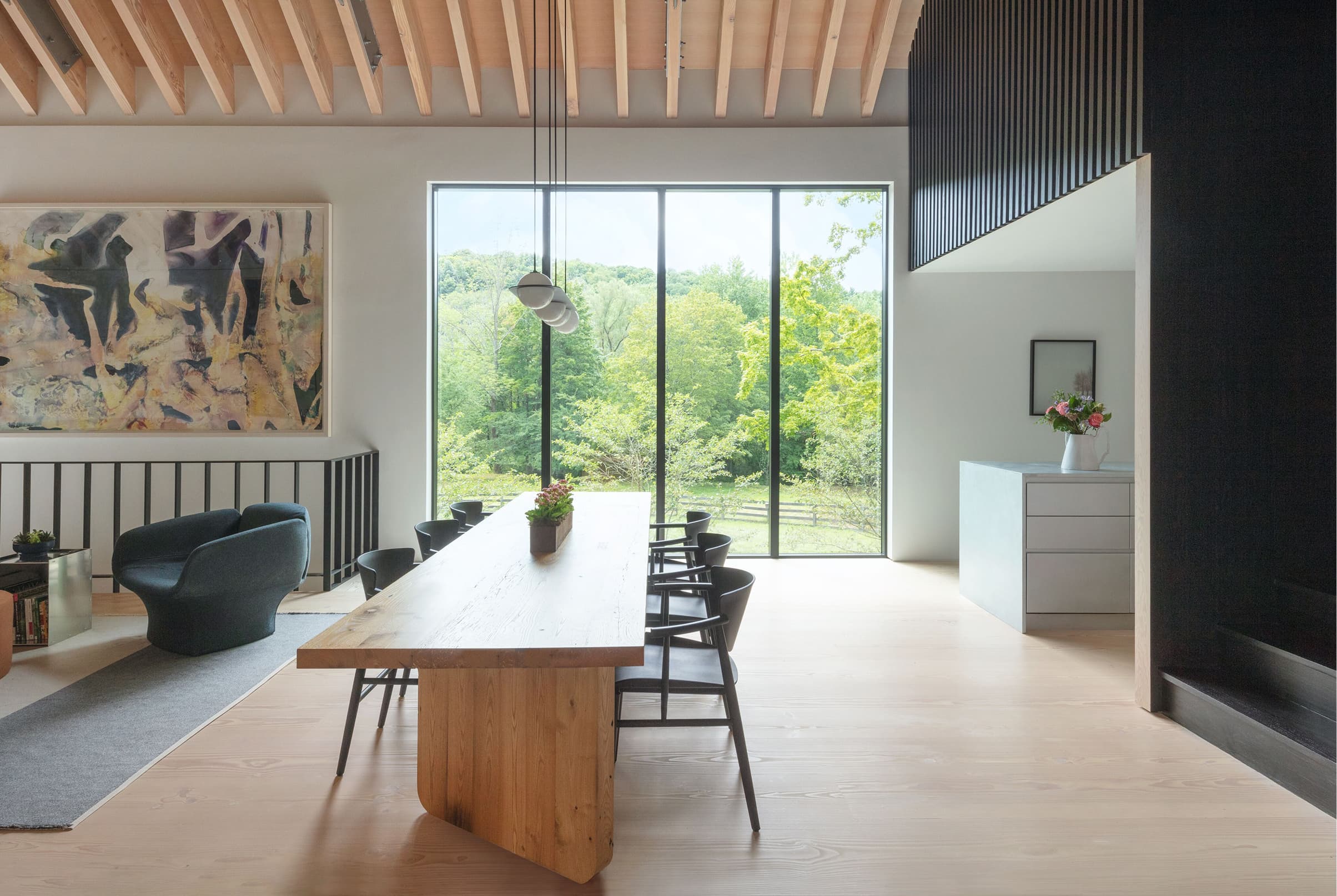 Home interior featuring a row of three black Marvin Modern Direct Glaze windows looking out to trees.