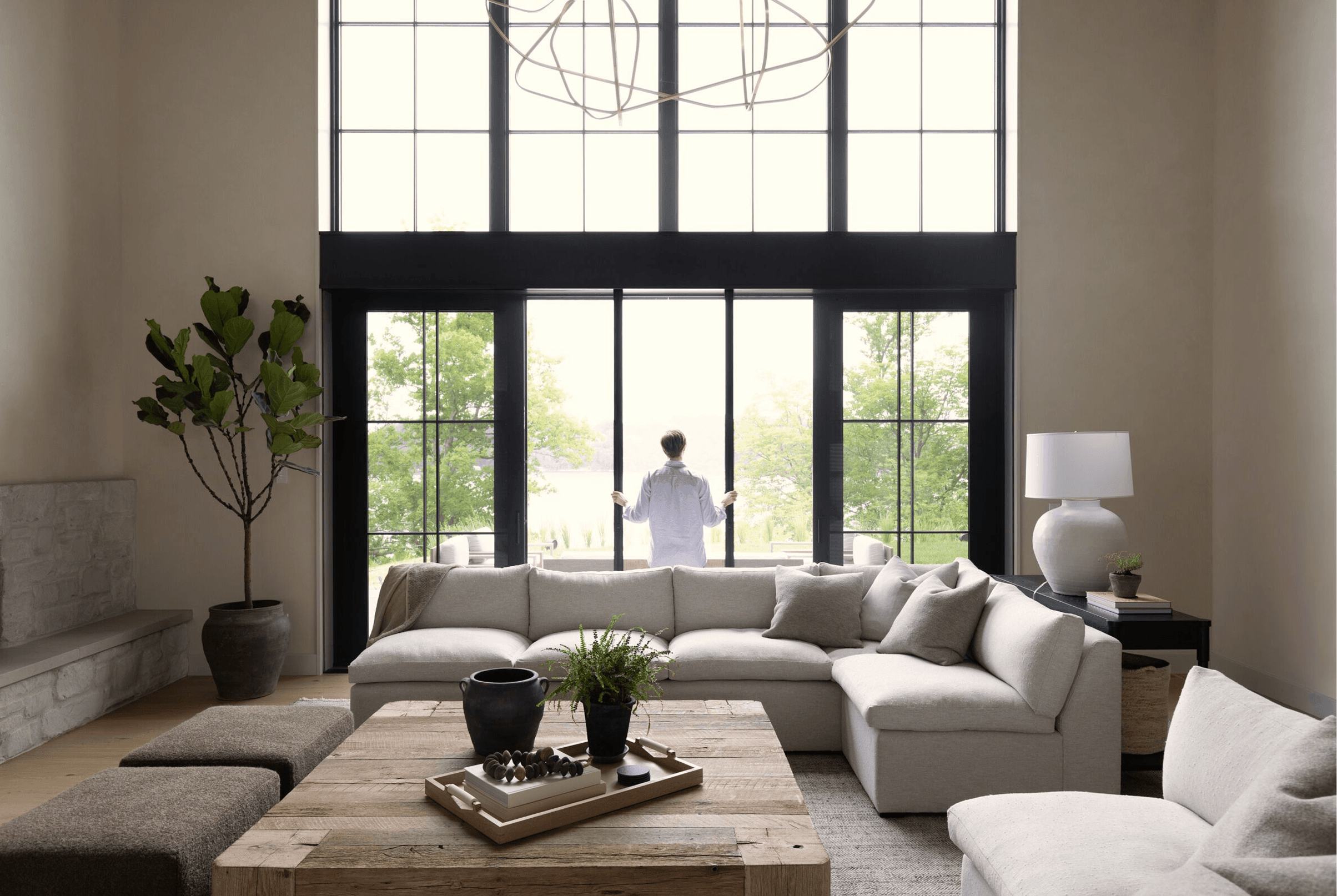 Living room interior with a person opening a Marvin Ultimate Sliding Door.