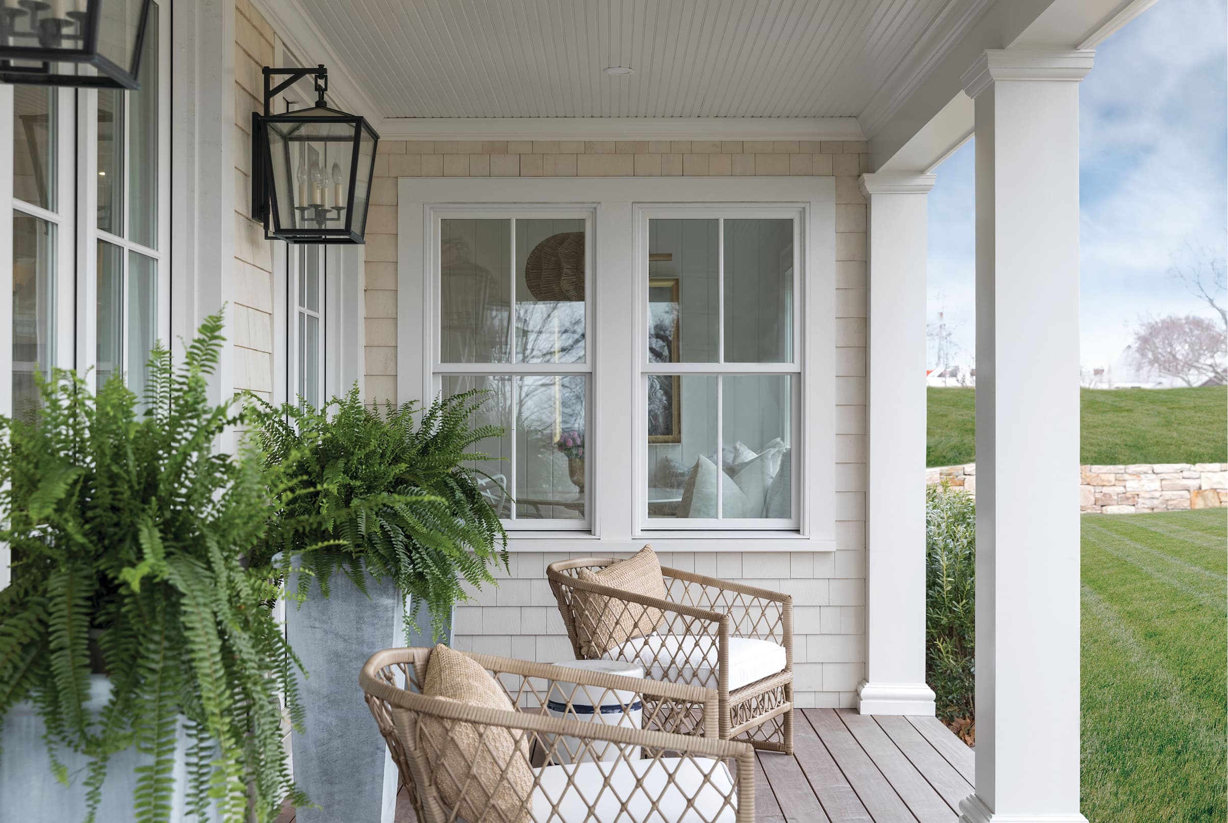 White home exterior porch featuring a pair of white Marvin Elevate Double Hung windows with grilles.
